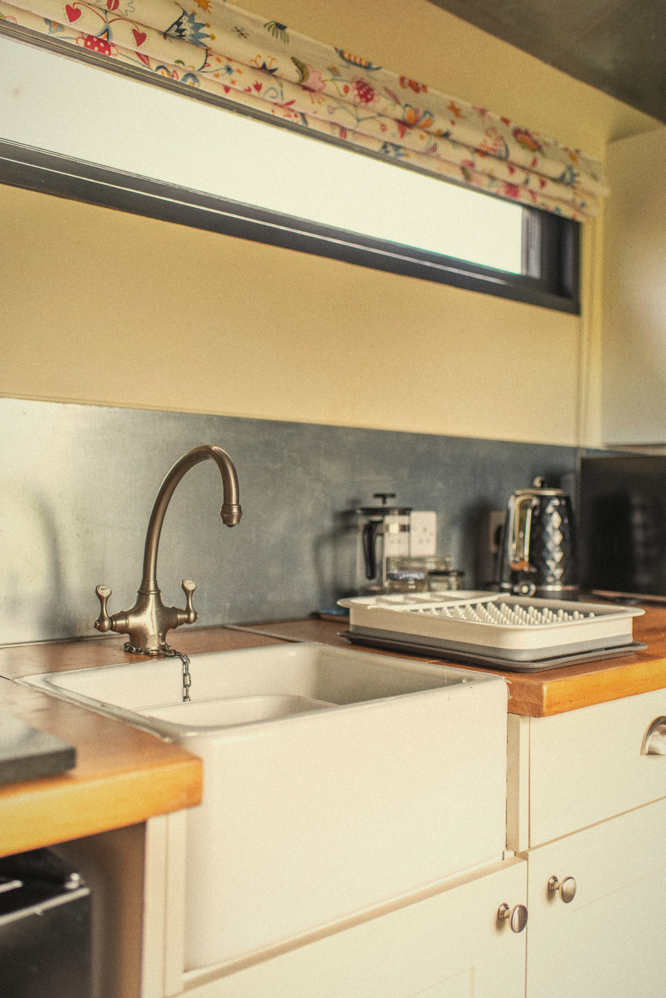 The kitchen sink and storage beneath the window