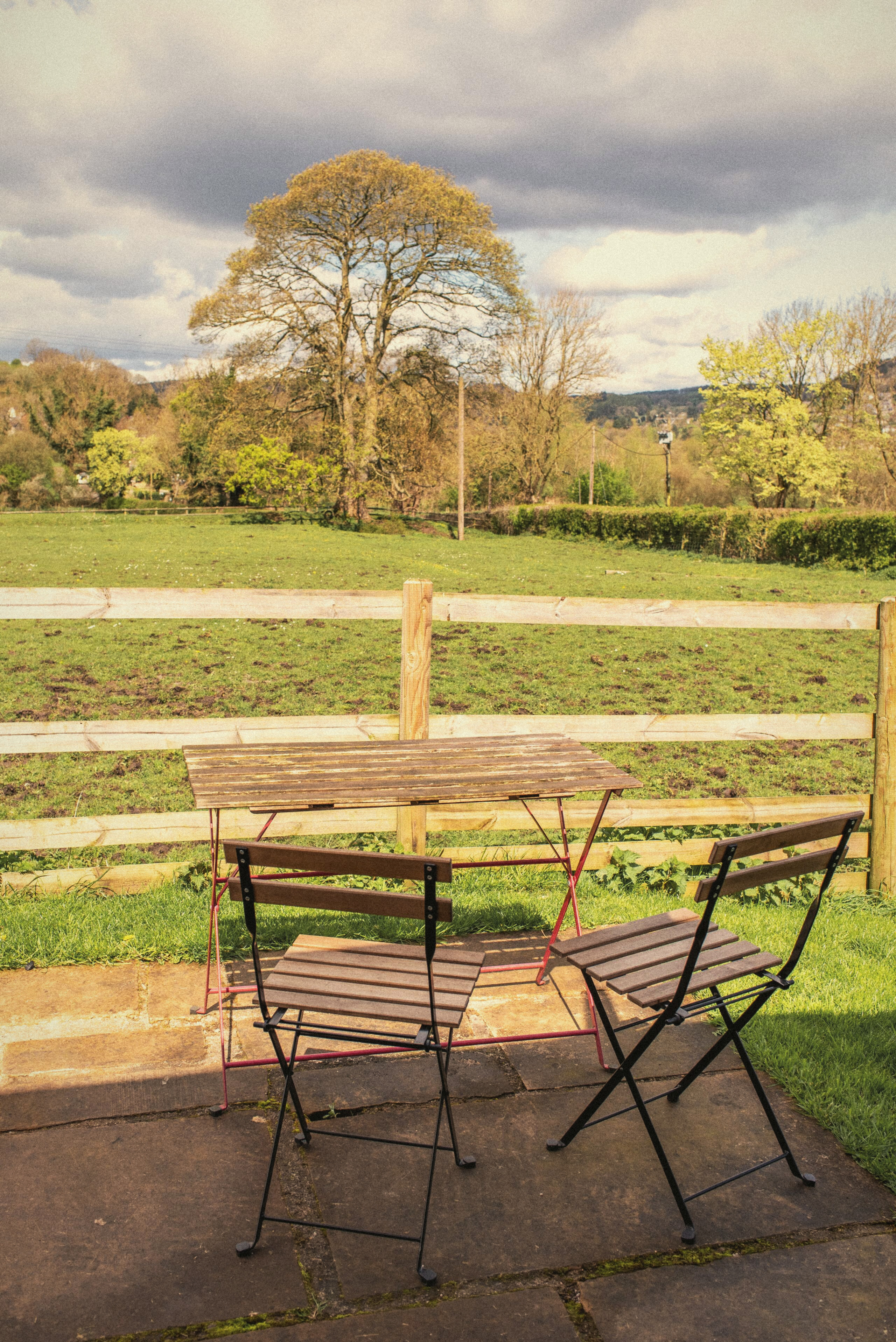 Patio chairs and table looking across the field and valley