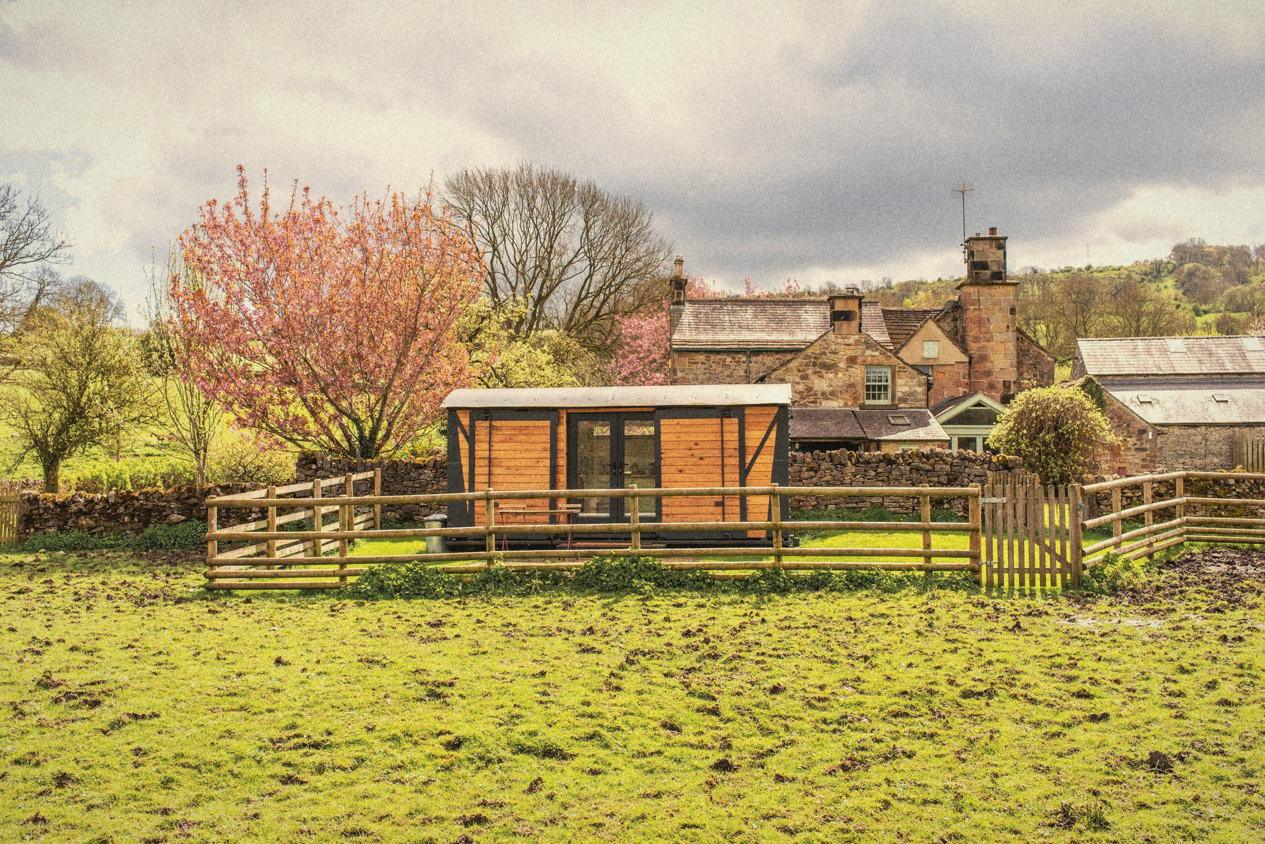 The Carriage and blossom trees with the hamlet behind