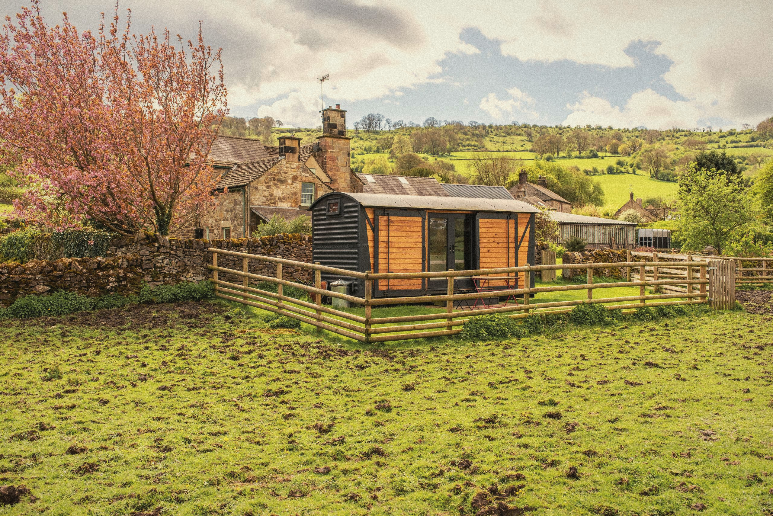 The timber-clad Carriage in its field below the manor