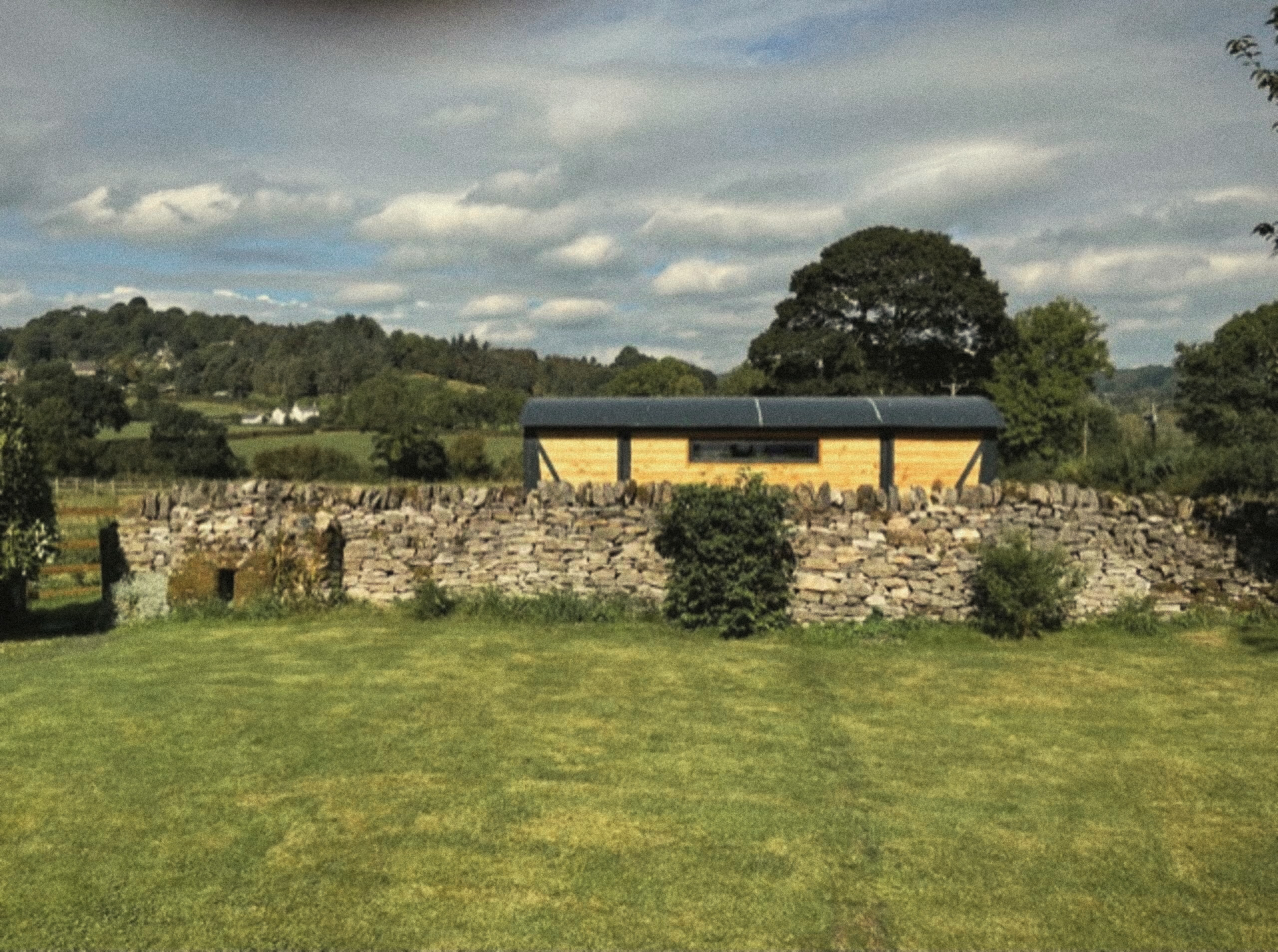 The Carriage behind a stone wall beside the field