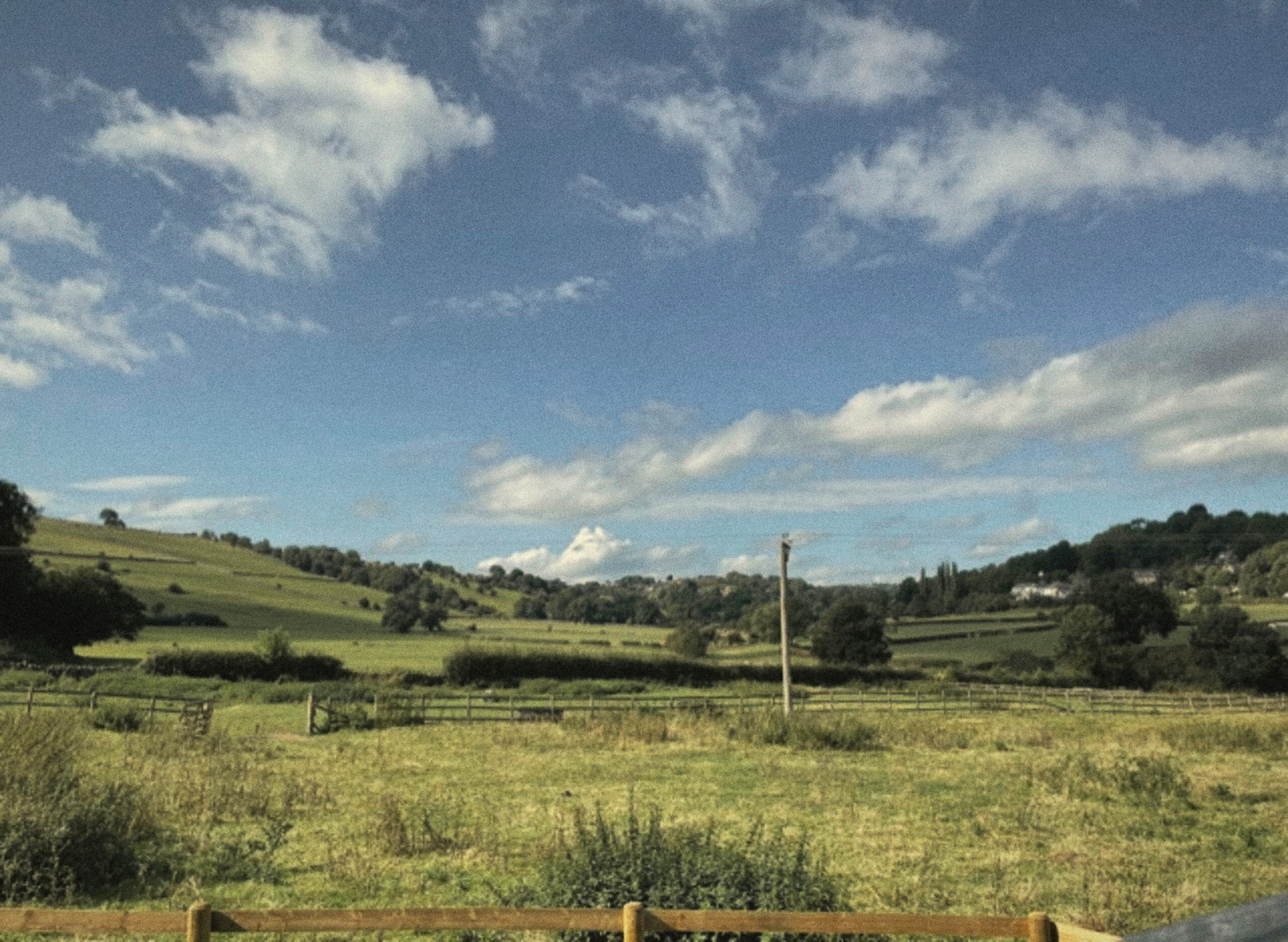 A view across the green field and countryside