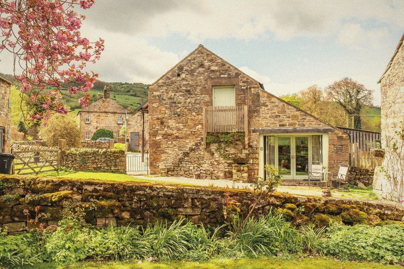 The Forge behind the garden wall and blossom tree