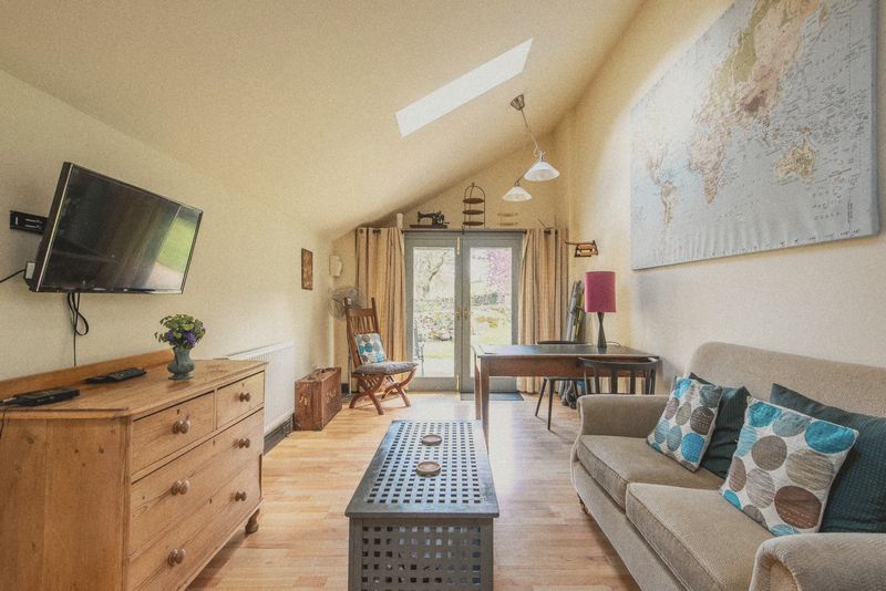 The sitting area with TV, settee and patio doors