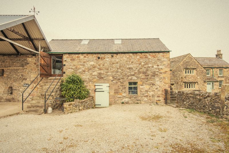 The stone barns and yard outside The Hayloft