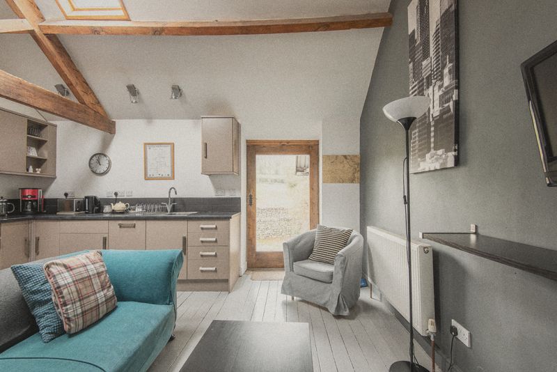 The vaulted lounge with teal settee and dining table