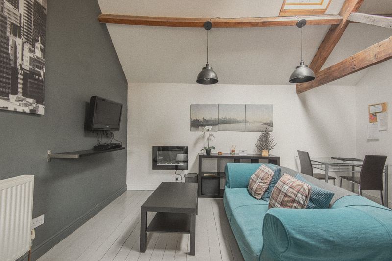 The lounge with wall-mounted TV and electric fire
