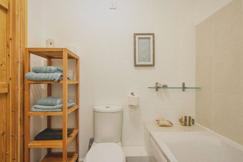 The bathroom with shelves, WC and bath