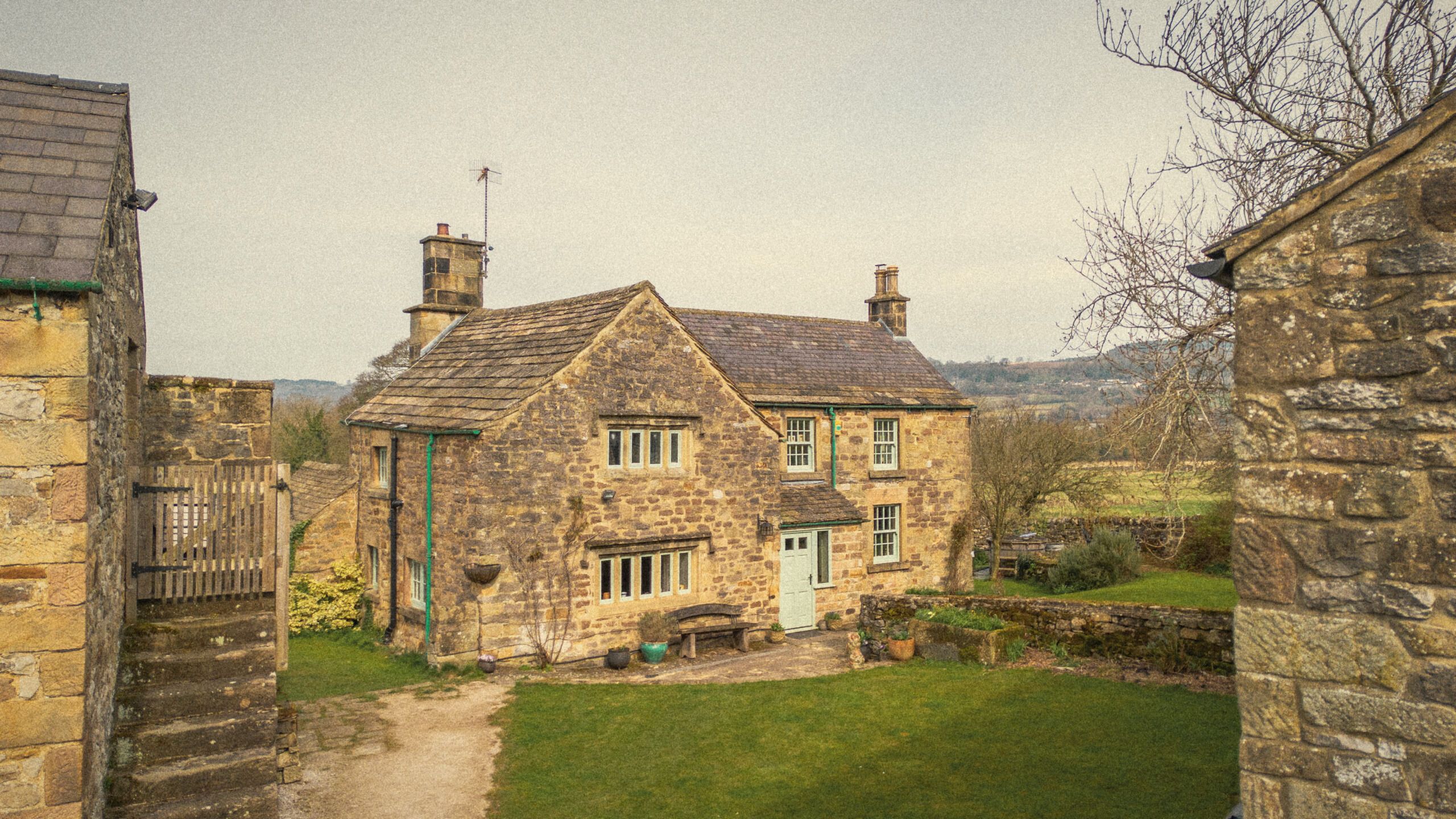 The front of The Old Manor House: honey stone, mullioned windows and the duck-egg front door