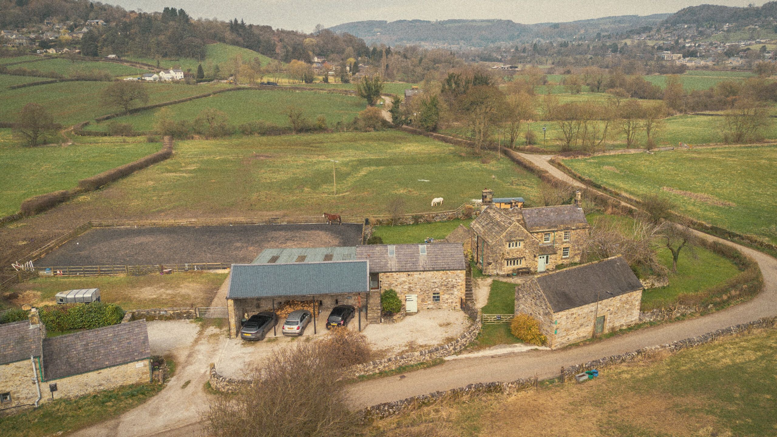 Snitterton from the air: the manor's stone barns and cottages among green fields and lanes