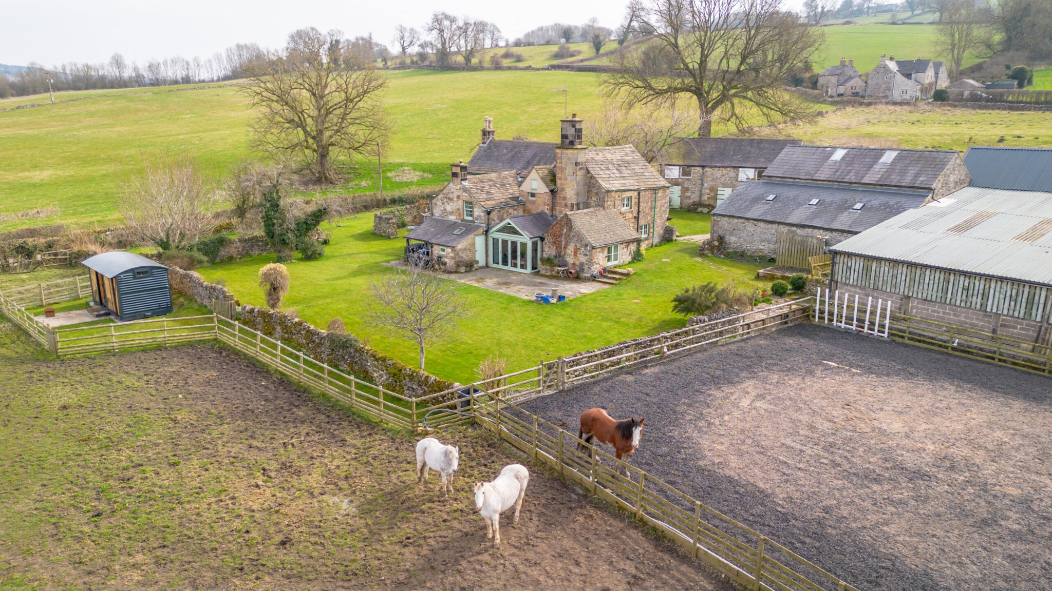 An aerial view of The Carriage, the manor and horses in the paddock