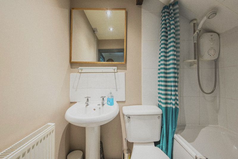 The bathroom with basin, WC and shower over the bath