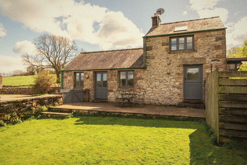 Thistledown Cottage’s stone front and garden in the sunshine